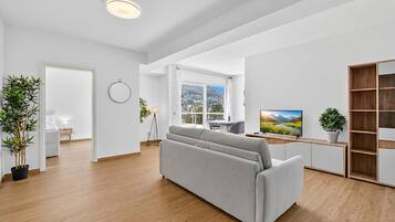 Un salon moderne avec un canapé, un téléviseur et une vue sur les montagnes.