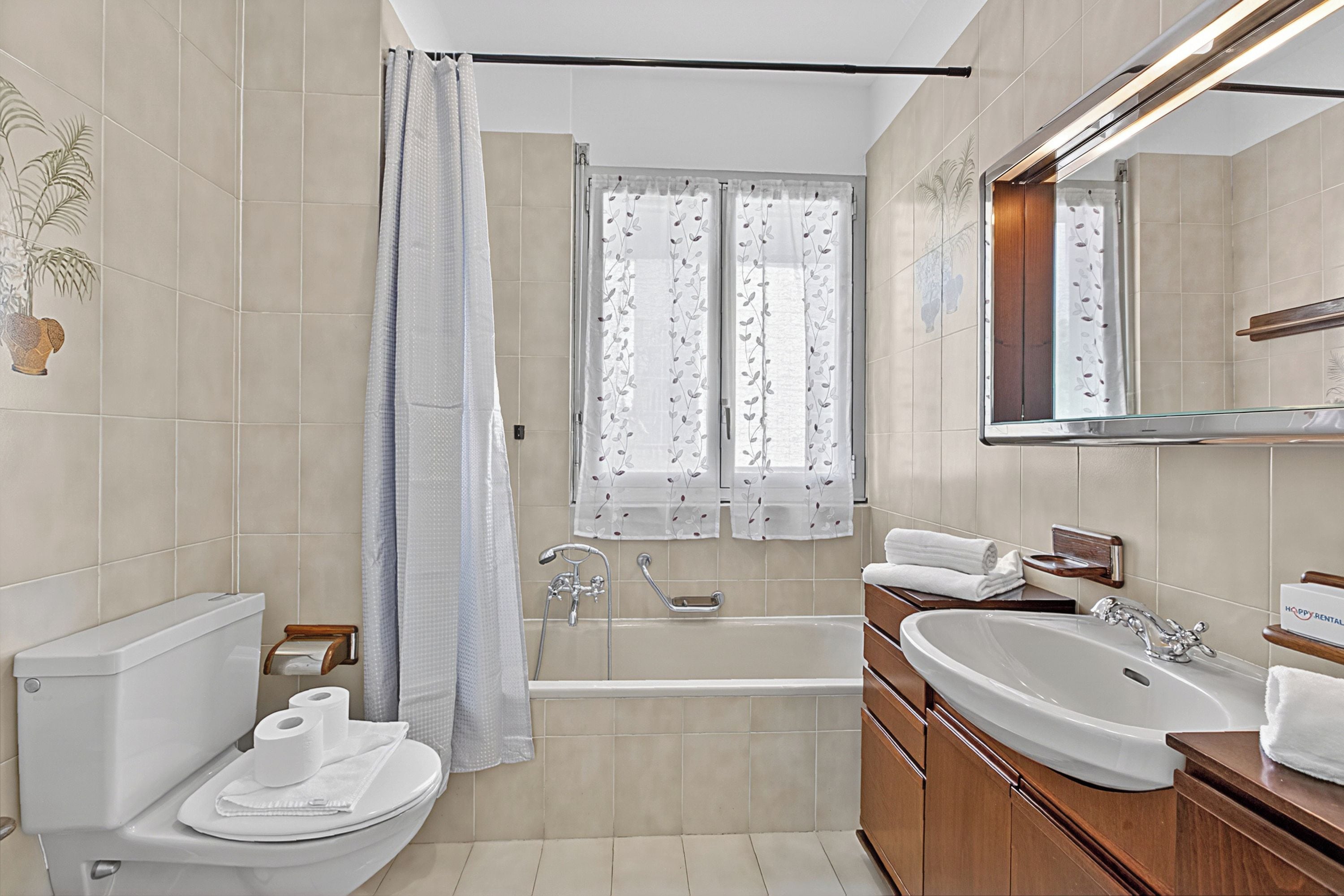 A bathroom with a toilet, bidet, bathtub, and a sink.