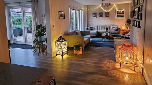 Un espace de vie spacieux comprenant un canapé, une table basse et des luminaires décoratifs.