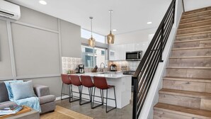 A modern kitchen with a central island, bar stools, and pendant lighting. - Perch - Capitol Luxe B | Prime Location in Cap Hill | Walk Score 93 (Seattle)