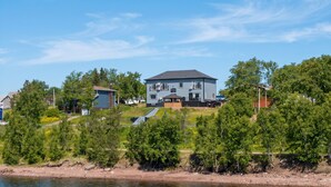A large two-story house with a flat roof, located near a body of water. - Falkenberg Business Centre and Suites (Botwood)