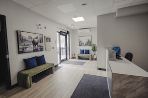 A reception area with a desk, bench, and two framed pictures on the wall.