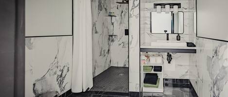 A modern bathroom with a toilet, shower, and sink area.