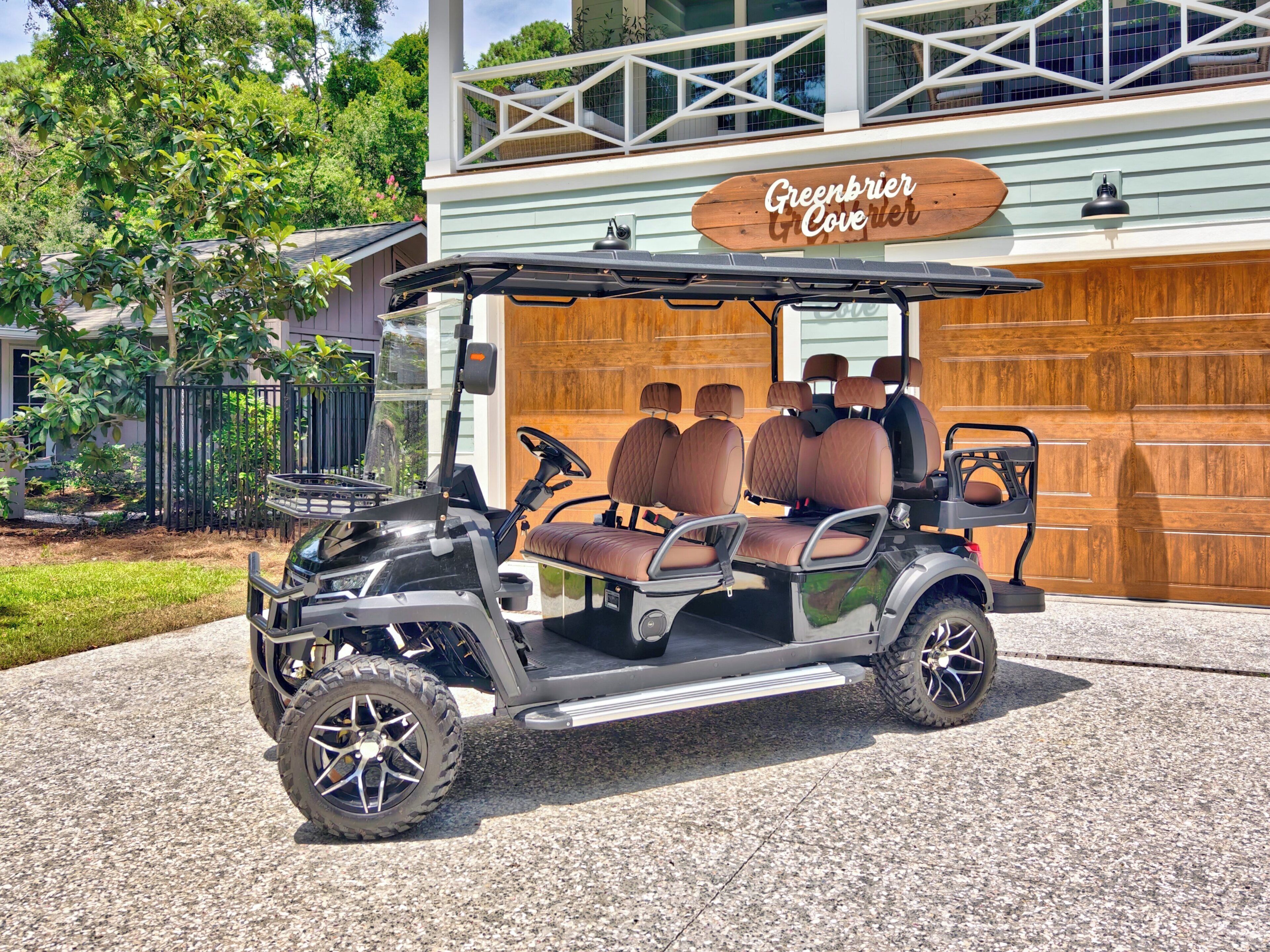 Um carrinho de golfe estacionado em frente a um edifício com uma placa que diz 'Greenbrier Cove'.