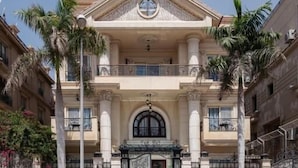 A multi-story building with a central entrance, balconies, and palm trees. - Maran Residence (Cairo Governorate)