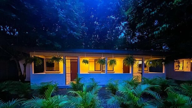 A modern building with large windows and a well-lit entrance. - Iguana Villas (Puerto Viejo de Talamanca)