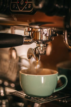 Gros plan sur une machine à café qui verse un expresso dans une tasse.