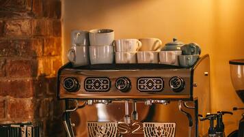 A coffee machine with multiple brewing options, a clock, and a branded coffee pot.