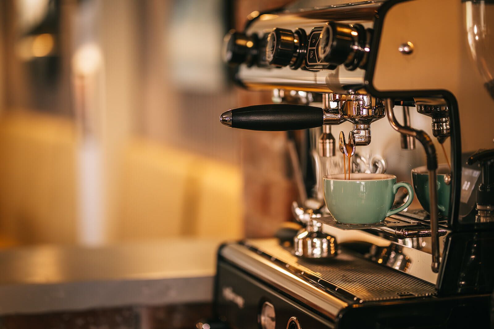 A coffee machine with a cup of coffee being brewed.