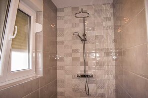 Een douche, handdoeken, zeep, toiletpapier