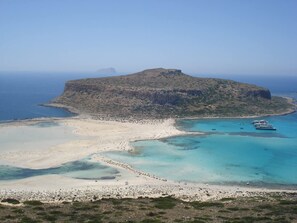 A coastal landscape with a sandy beach, clear turquoise waters, and a rocky hill in the background. - Wester Sun new Apartment Near Balos Falassarna (Kissamos)