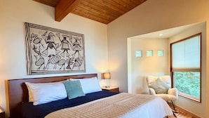 A bedroom with a large bed, a headboard, a wall-mounted artwork, a bedside lamp, a chair, and a window with blinds. - Luxury Bay Retreat Hot Tub Views (Bellingham)