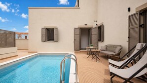 A rooftop pool with a clear blue pool, a lounge area with a sofa and chairs, and a door leading to a balcony. - Bon Filius - Luxury Private Villa w Pool in Chania (Apokoronas)