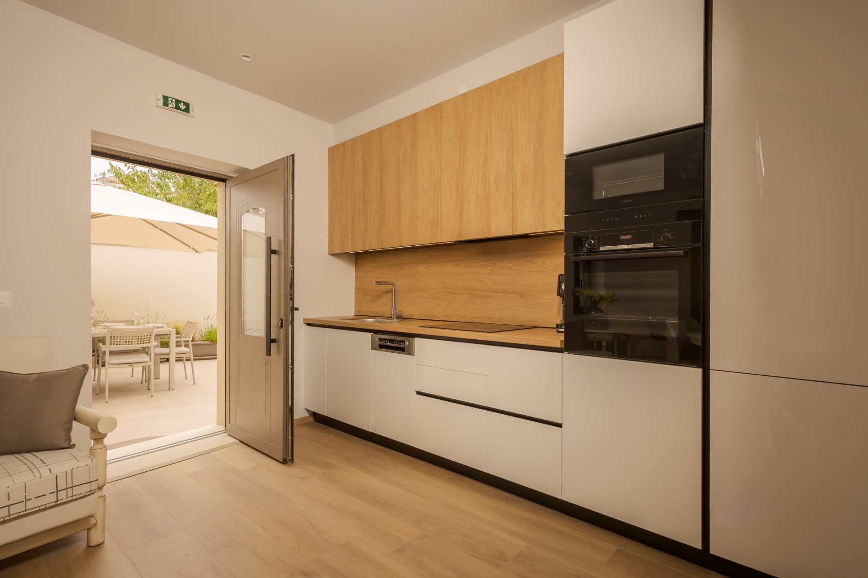 A modern kitchen with wooden cabinets, a built-in oven, and a dishwasher.