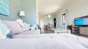Una sala de estar moderna con un sofá, un televisor y un comedor.