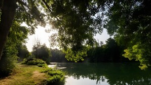 A calm river surrounded by dense greenery and trees. - Holiday Home “Dormitory in Charente” with Private Terrace and Shared Garden (Jarnac)