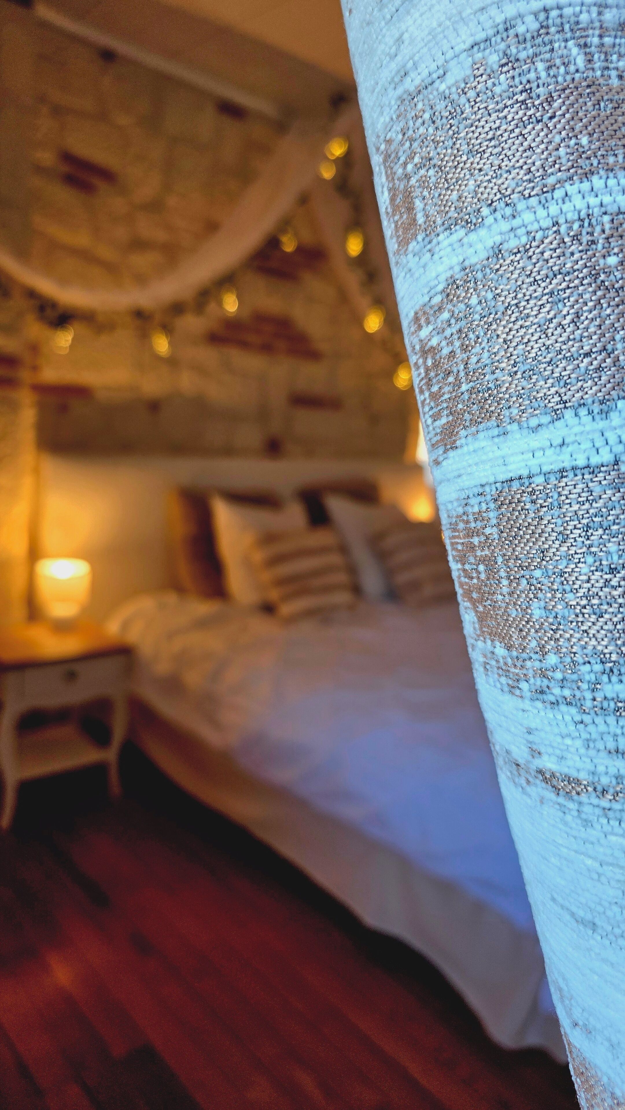 Een slaapkamer met een bed, nachtkastjes en een hanglamp.