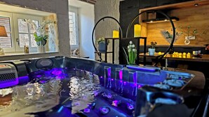 A spa area with a hot tub, wooden accents, and potted plants. - Exceptional setting with Jacuzzi and cinema room for a suspended moment for 2 (Penne-d'Agenais)
