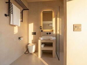 A modern bathroom with a toilet, sink, towel rack, and a mirror. - Guesthouse Ubuntu (Stellenbosch)