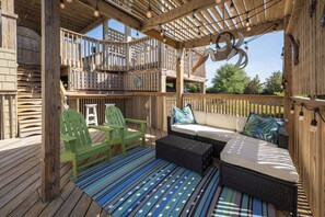 A wooden deck with outdoor furniture, including a sofa and chairs, and a pergola with string lights. - New Listing, King Beds, Dogs, Private Pool, Walk to Beach D0109 (Duck)