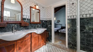 Ein Badezimmer mit zwei Waschbecken, einem großen Spiegel und einer Duschkabine.