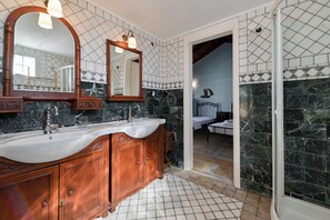 Ein Badezimmer mit zwei Waschbecken, einem großen Spiegel und einer Duschkabine.