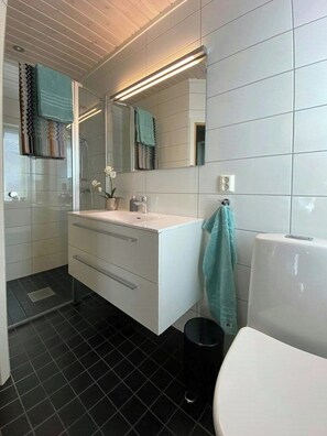 A modern bathroom with a white vanity, a mirror, a towel rack, and a toilet. - Apartment for year-round holidays in Golsfjellet (Gol)
