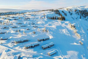 Et snelandskab med flere hytter og en stolelift.