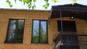 A brick building with two windows and a balcony with a wrought iron railing. - DRO Hotel (Kutaisi)