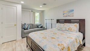 Ein Schlafzimmer mit einem Bett, einer Couch, einer Tür und einem Fenster.