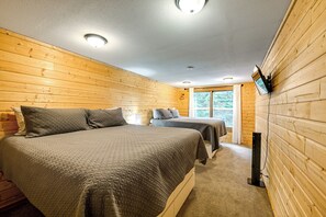 A room with two beds, wooden walls, a ceiling light, and a TV mounted on the wall. - Group Escape w/ Hot Tub, 18 Mi to Bavarian Village (Leavenworth)
