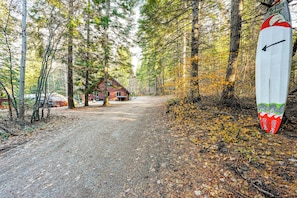 A forested area with a cabin and a surfboard leaning against a tree. - Group Escape w/ Hot Tub, 18 Mi to Bavarian Village (Leavenworth)