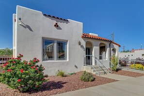 A single-story building with a stucco exterior, a tiled roof, and a small porch with steps. - Walkable Home w/ Office in Downtown Albuquerque! (Albuquerque)
