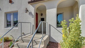 A building with a stucco exterior, a set of concrete stairs with metal railings, and a small plant in the foreground. - Walkable Home w/ Office in Downtown Albuquerque! (Albuquerque)