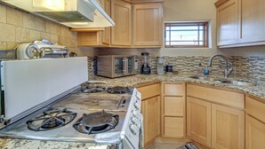 A kitchen with a stove, microwave, and sink. - Walkable Home w/ Office in Downtown Albuquerque! (Albuquerque)