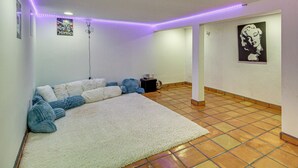 A room with a large white carpet, a sofa, and a small table. - Walkable Home w/ Office in Downtown Albuquerque! (Albuquerque)