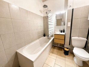 Kylpyhuone, jossa on kylpyamme, wc, pesuallas ja peili.