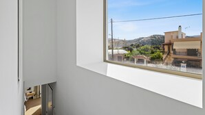 Une pièce avec une grande fenêtre, un lit et un bureau.