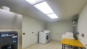 A laundry room with an ice dispenser, washing machines, and a table. - Walk to Boardwalk & Beach! Ocean City Studio (Ocean City)