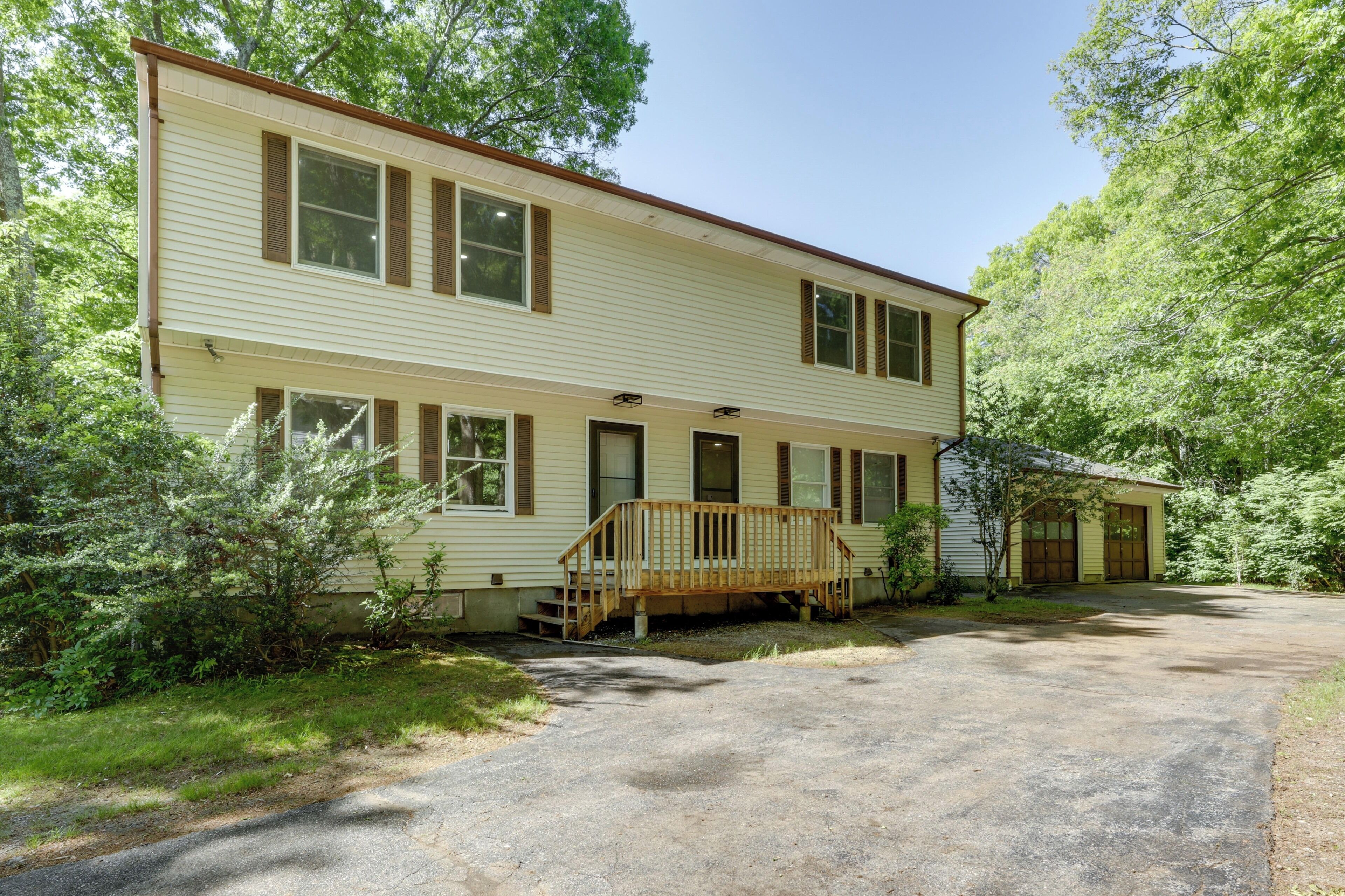 A two-story house with a front porch, a driveway, and a garage.