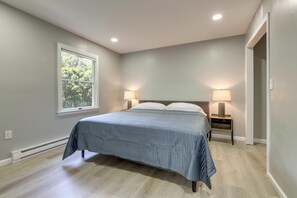 A bedroom with a bed, two bedside lamps, a window, and a door. - Modern Home, Minutes to Mystic, Casinos and Ocean (Groton)