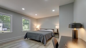 A bedroom with a bed, bedside tables, a desk, and a lamp. - Modern Home Minutes to Mystic, Casinos and Ocean (Groton)