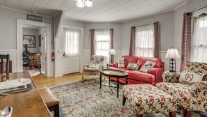 A living room with a red sofa, patterned ottomans, a wooden coffee table, and a floral rug. - 2 Mi to Beach & Boardwalk! New London Haven (New London)