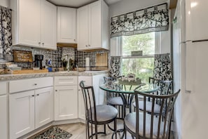 A kitchen with white cabinets, a glass table, and patterned curtains. - 2 Mi to Beach & Boardwalk! New London Haven (New London)