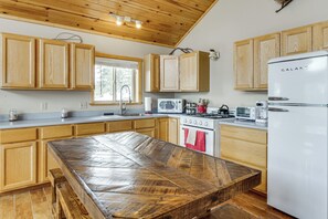 A kitchen with wooden cabinets, a white refrigerator, a stove, and a microwave.