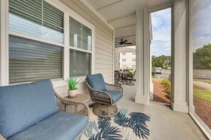 A porch with wicker furniture, a ceiling fan, and a view of a parking lot. - Golf + Poolside Days! Condo 9 Mi to Sunset Beach (Calabash)