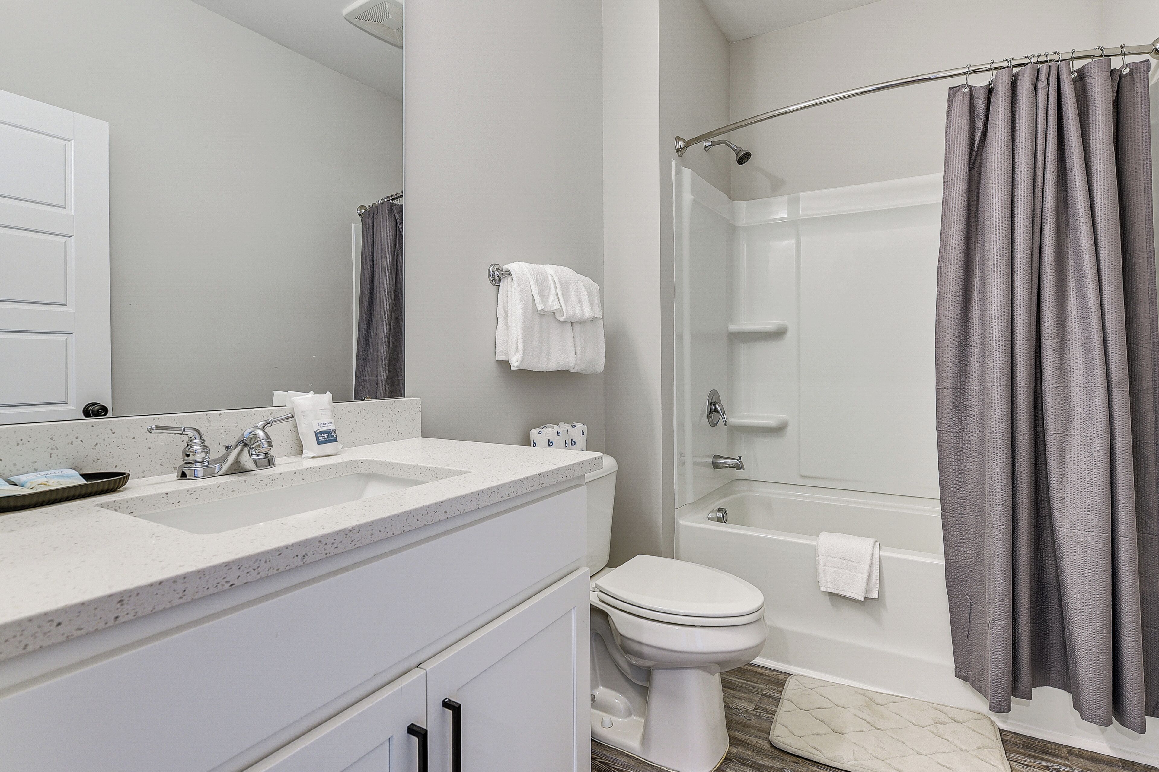 Une salle de bain avec un lavabo, des toilettes et une baignoire, le tout de couleur blanche.