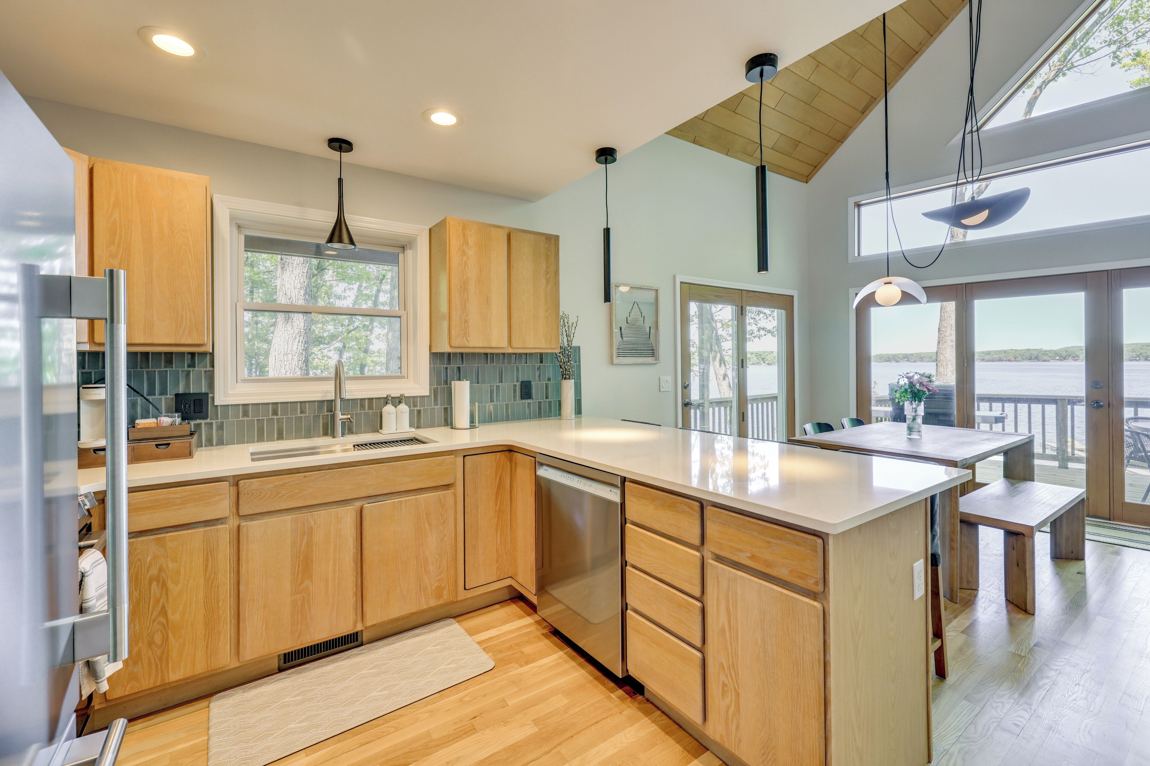 A modern kitchen with wooden cabinets, a dishwasher, and a large island.