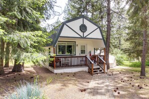 A cabin with a wooden deck, a staircase, and a fire extinguisher.
