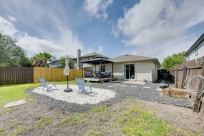 A backyard with a patio, outdoor seating, and a covered area. - Private Yard & Deck! Group-friendly Haven in Manor (Manor)